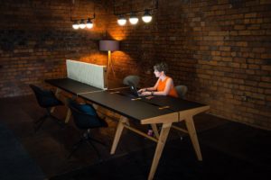 Woman working at Mutu table in bare brick office
