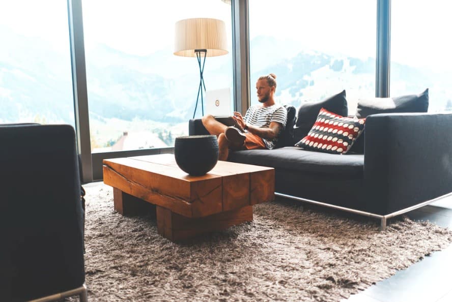 Man using a laptop sitting on a sofa