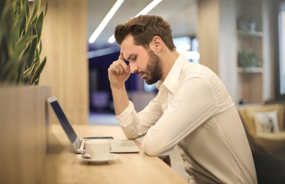 Pensive man using laptop