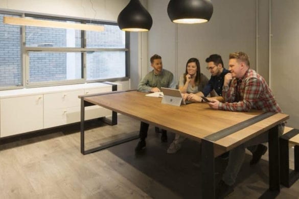 4 people sat around Haag Bench in office space
